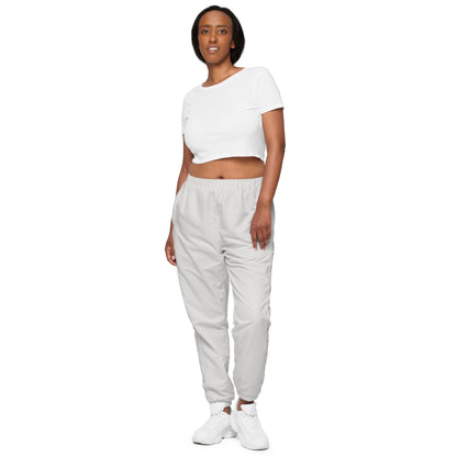 Model wearing unisex platinum track pants and white crop top, showcasing lightweight, water-resistant fabric and stylish design.