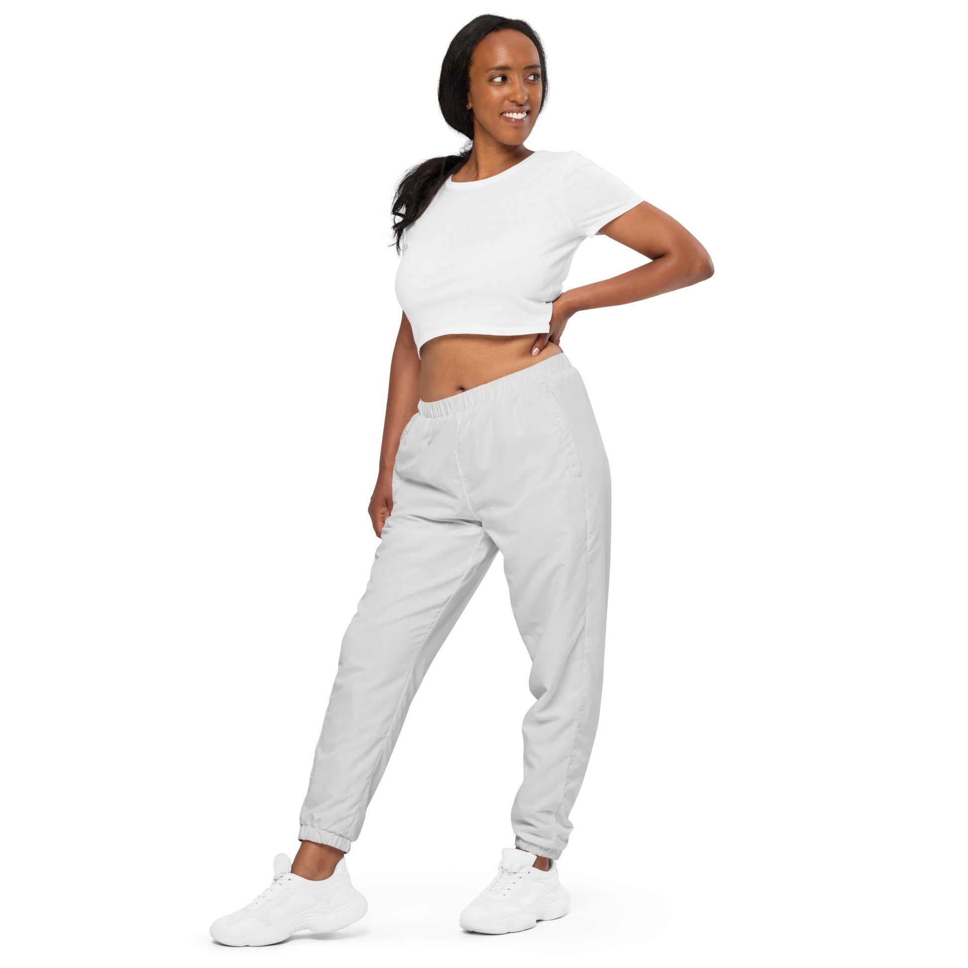 Unisex track pants in light grey showcased by a model, perfect for workouts or streetwear styles.